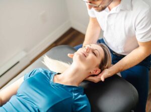 A young adult athlete receiving a chiropractic adjustment on their back from a licensed practitioner.